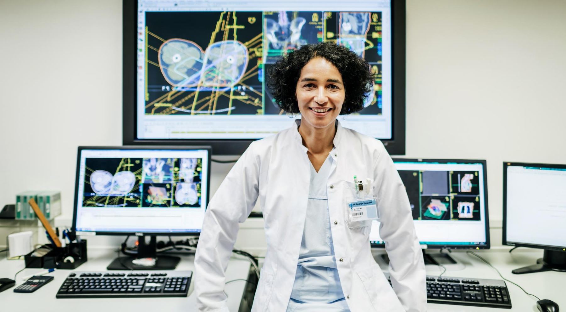 Médica frente a monitores con imágenes diagnósticas
